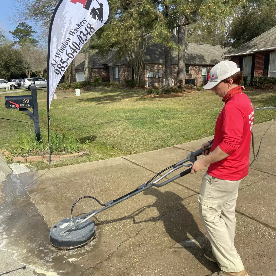 Image of house washing professional washing a concrete driveway