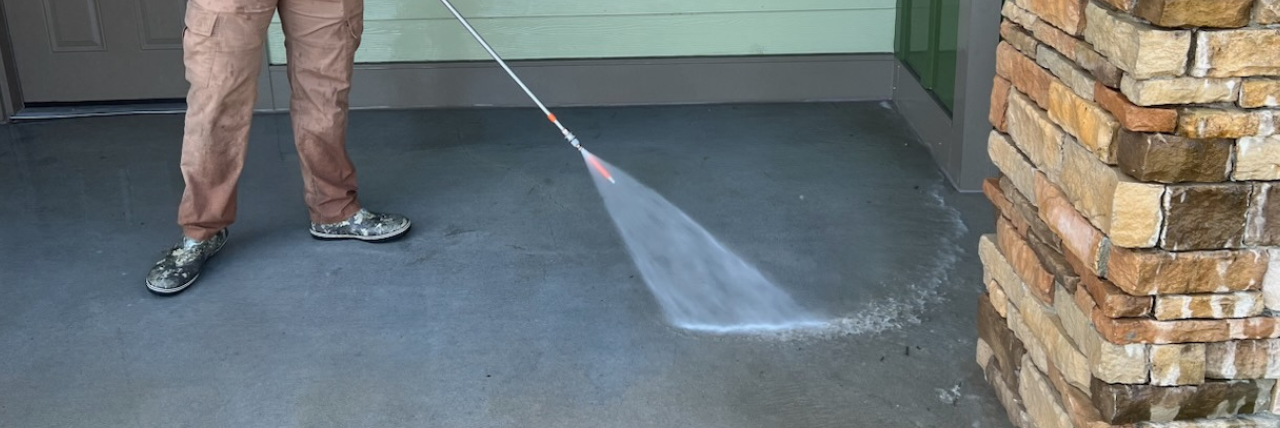 Image of house washing professional washing a brick building