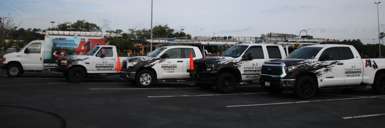 Image of A-1 Window Washers company trucks lined up nicely in a parking lot